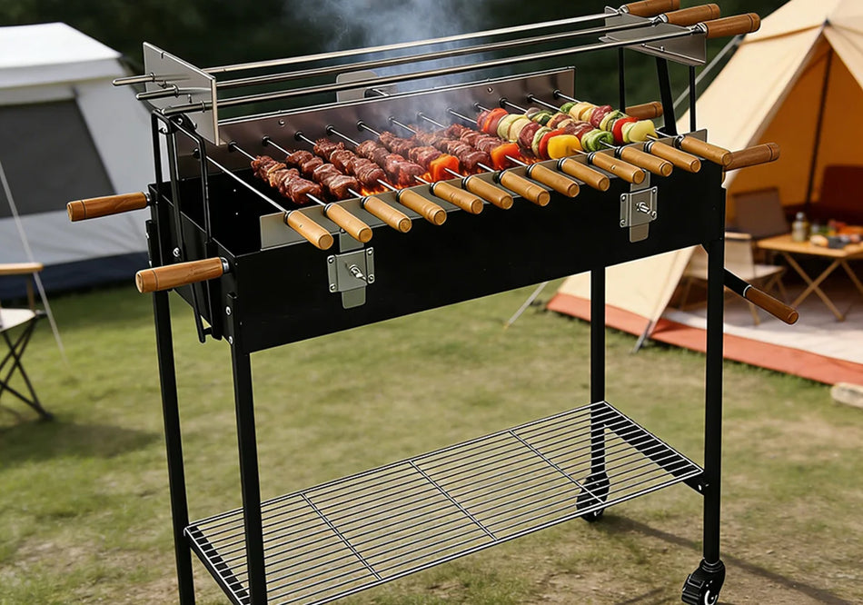A black outdoor charcoal grill with wooden handles and a lower wire shelf, shown cooking skewers on a grassy campsite with tents in the background.